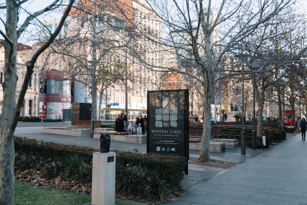 An advertising board with a poster for Mineral Lines.